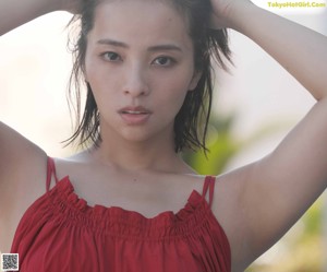 A woman in a red dress is posing for a picture.