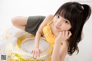 A woman in a yellow top and a straw hat.