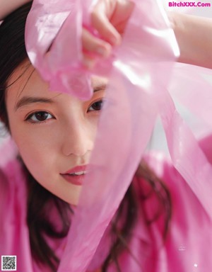A young woman with long black hair and a blue shirt.