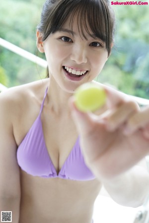 A woman in a pink bathing suit posing in a bathroom.