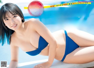 A woman in a black bikini sitting in a bathtub.