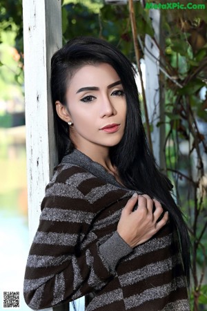 A woman in a black bra top and black pants posing for a picture.