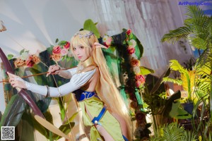A woman in a costume holding a bow and arrow.