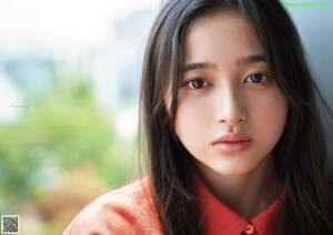 A woman with long black hair wearing a red shirt.