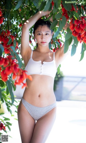 A woman in a white bra and panties posing for a picture.