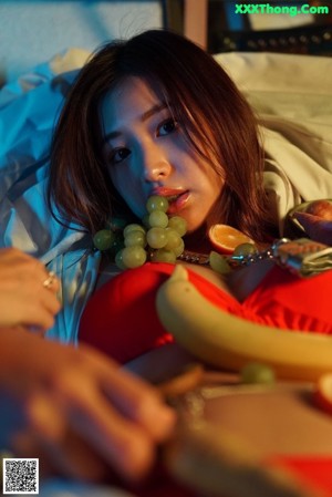 A woman in a black lingerie sitting on a table.