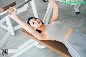 A woman in a black bra and white panties posing for a picture.