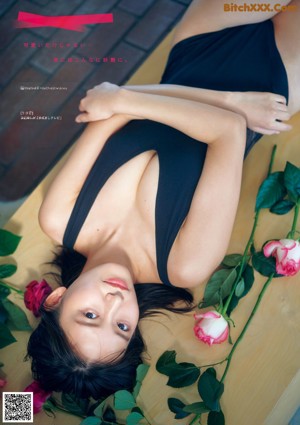 A woman in a pink dress sitting on the floor.