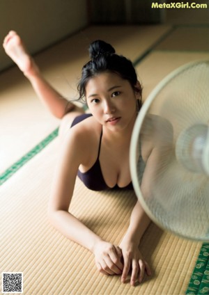A woman in a white shirt and black skirt standing in a pool.