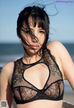 A woman in fishnet stockings is posing for the camera.